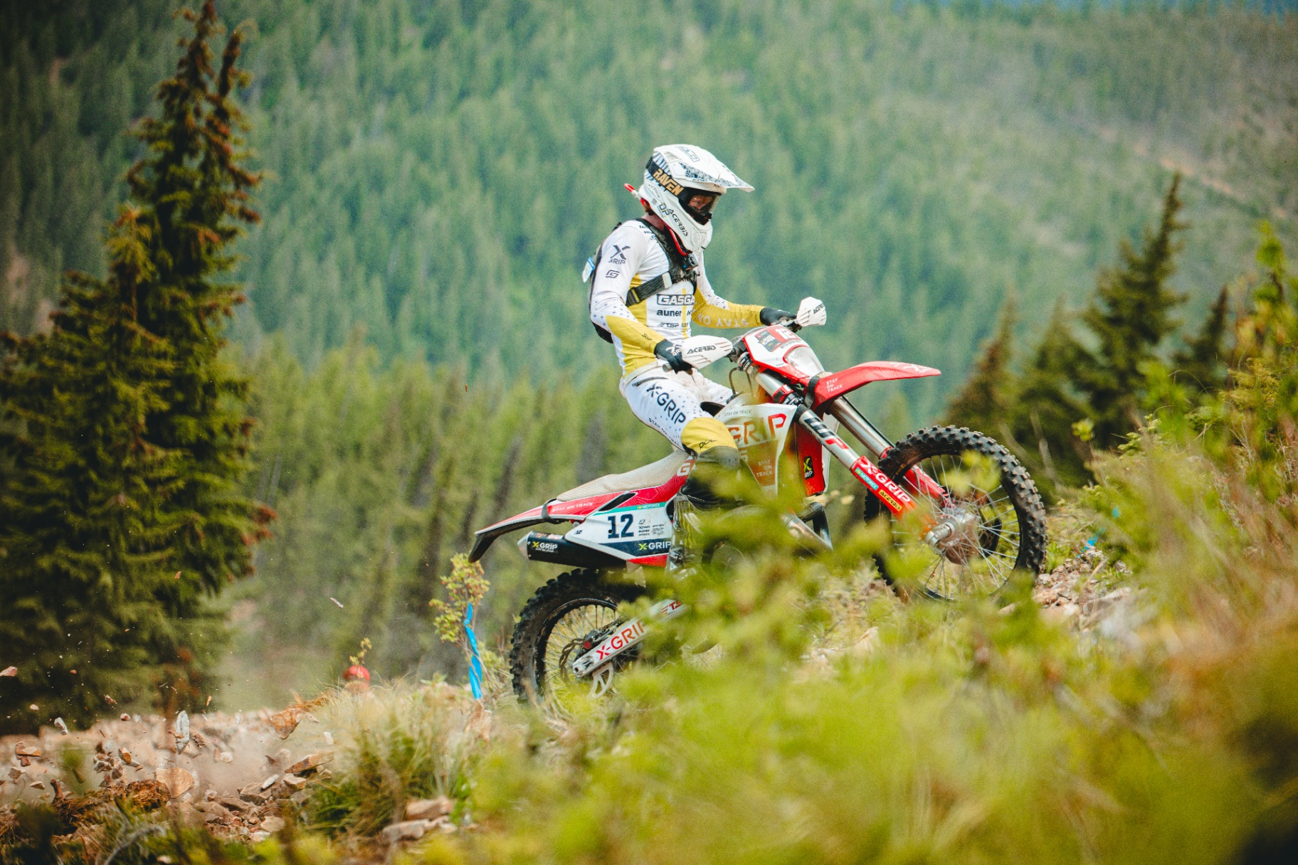 Hard enduro rider climbing a steep grassy mountain trail